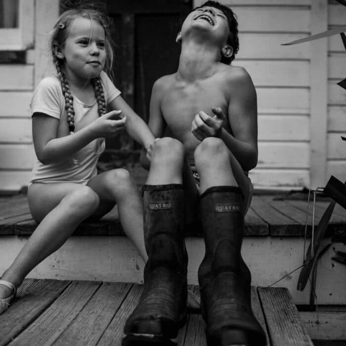Black and white photo of a young girl and boy laughing together