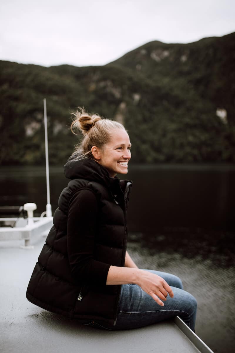 Maria, smiling as she sits on the top deck of the Flightless. Together, Maria and Seán lead a family-like team. They spend their time on- and off-shore exploring and conserving southern Fiordland.