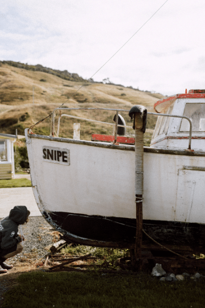 The Snipe 7519 is an old wooden working boat berthed permanently at Cosy Nook – supported by wooden pylons, it hasn’t been wet for some years. Photos of the boat from decades ago, when it sailed the around the Southland coast, still hang on the walls at the pub in nearby Kaka Point. 
