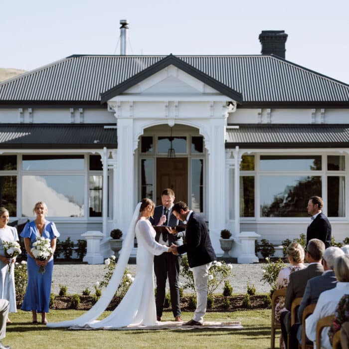 A couple getting married in front of an historic homestead.