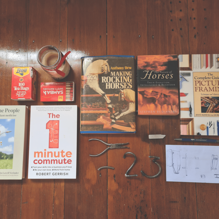 Flat lay image of assorted books, small sculptures and bric-a-brac found on Sharon's bedside table.