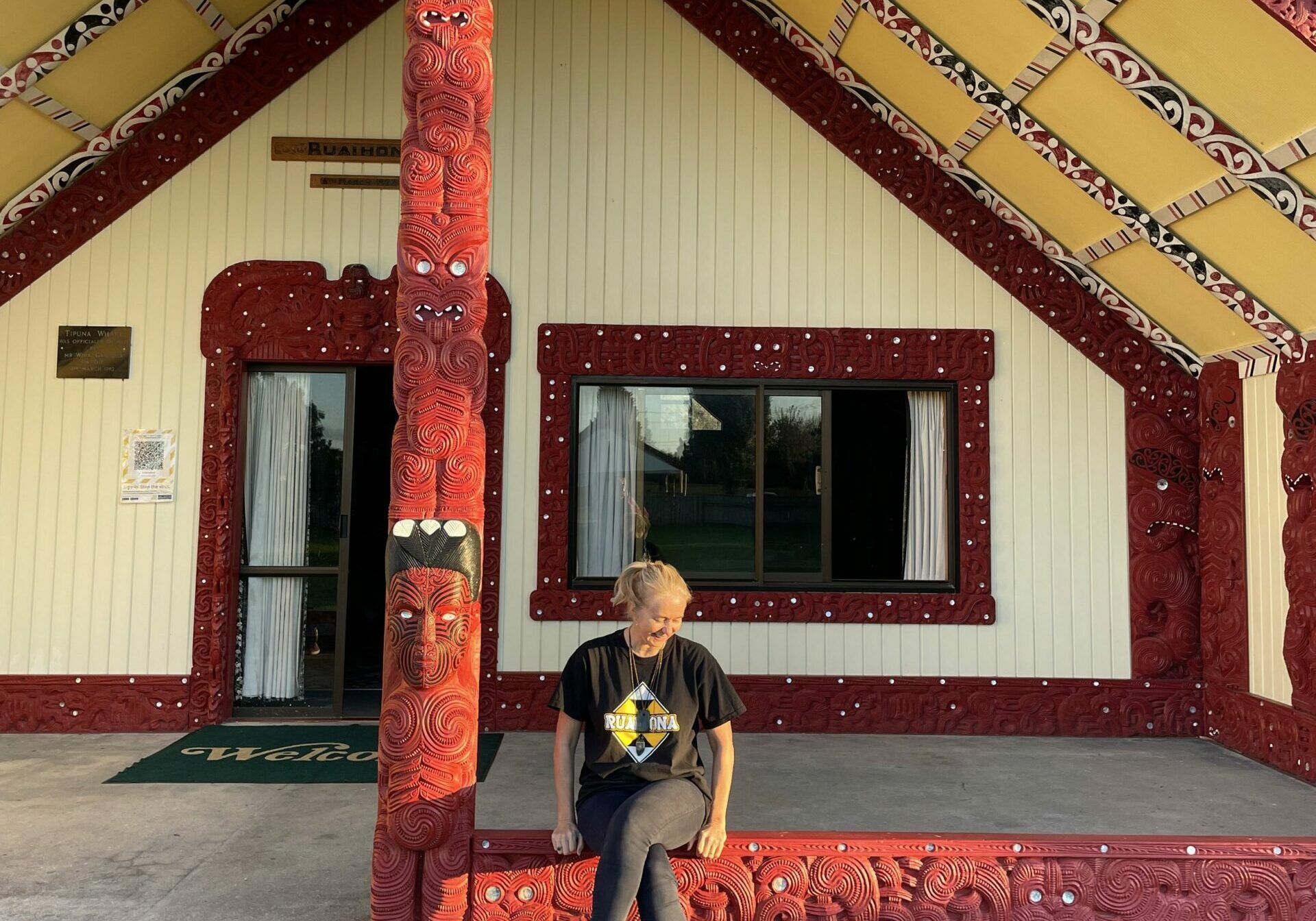 In Te Teko, Sara is known by her friends and whānau as Hera or, fondly, The Blonde. This image of Sara sitting in front of the wharenui of her marae - Ruaihona - in Te Teko was taken by Lesley Savage.