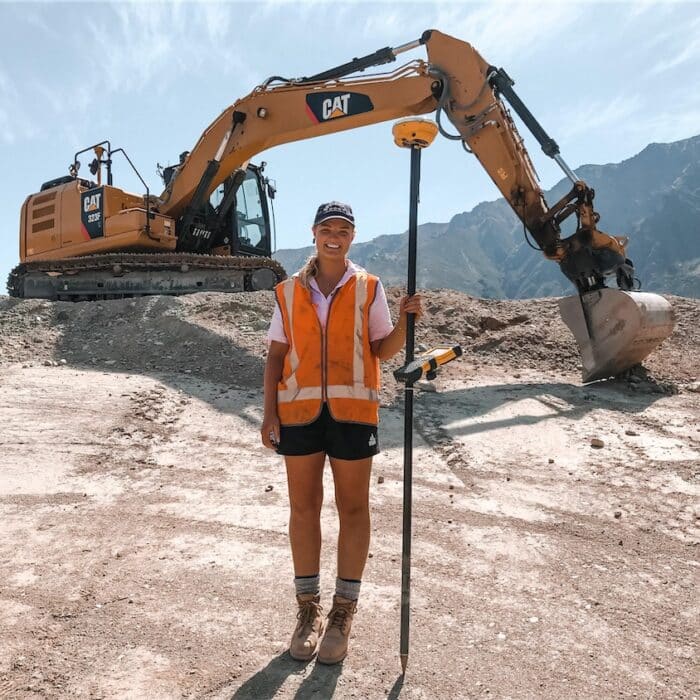 Olivia Thomson standing in front of a digger